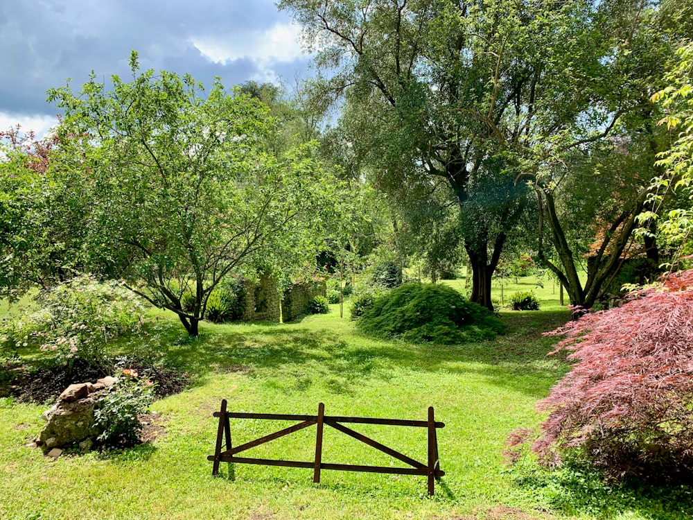 banco de madeira marrom no campo verde da grama