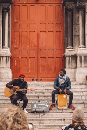 man in blue jacket playing guitar