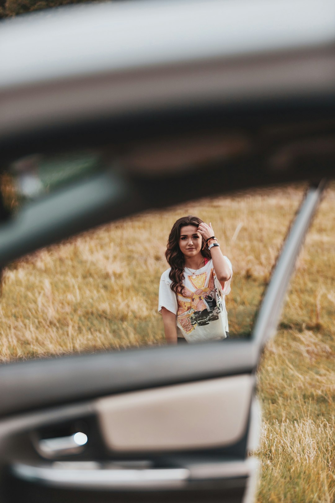 woman in white and black floral dress sitting on car