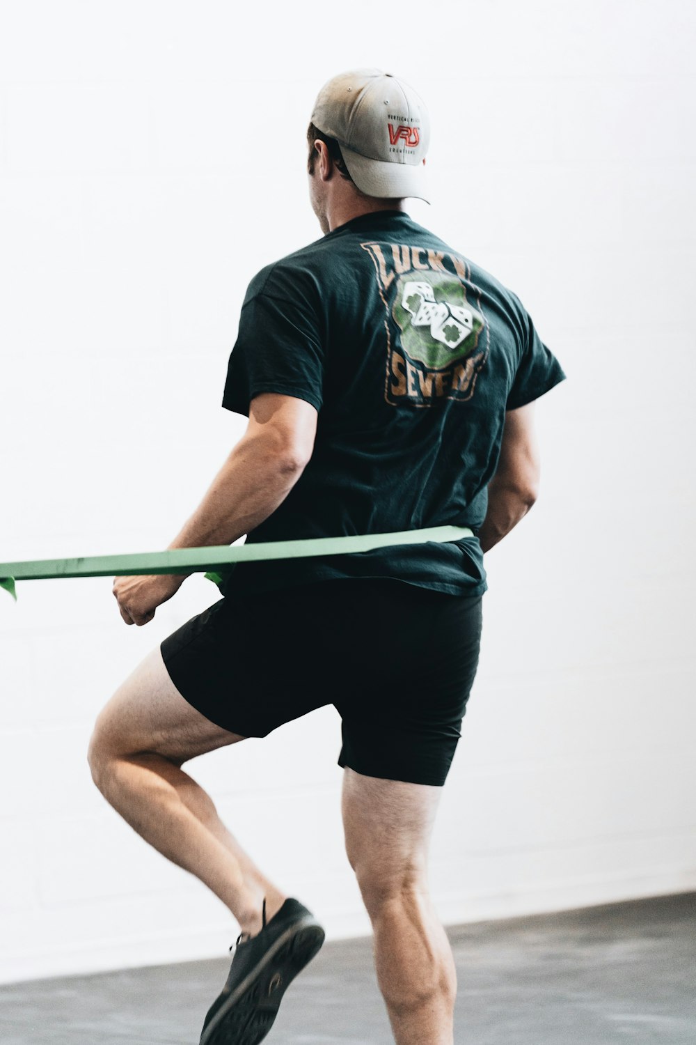 man in black and green crew neck t-shirt and black shorts holding green stick