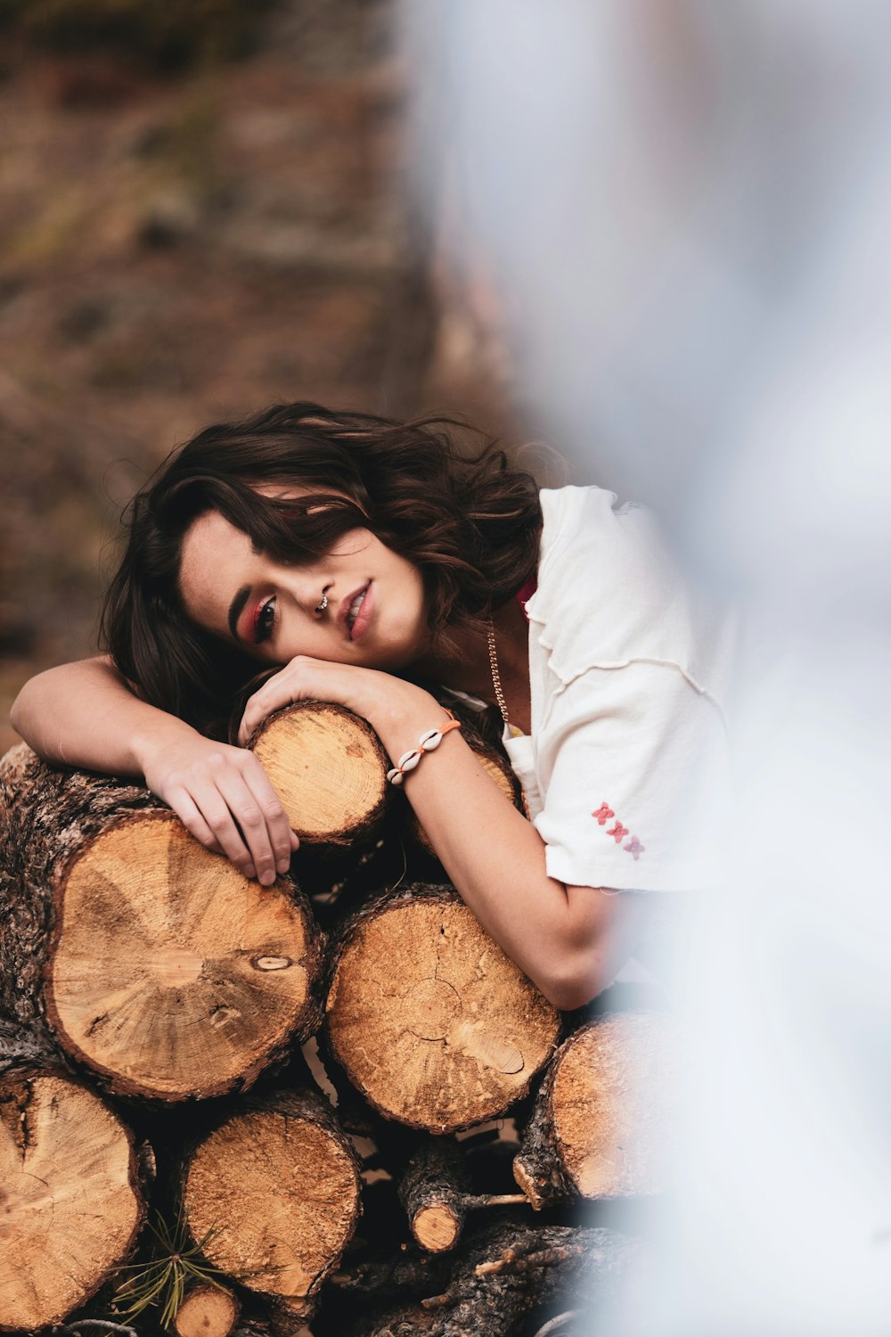 woman in white t-shirt lying on brown log