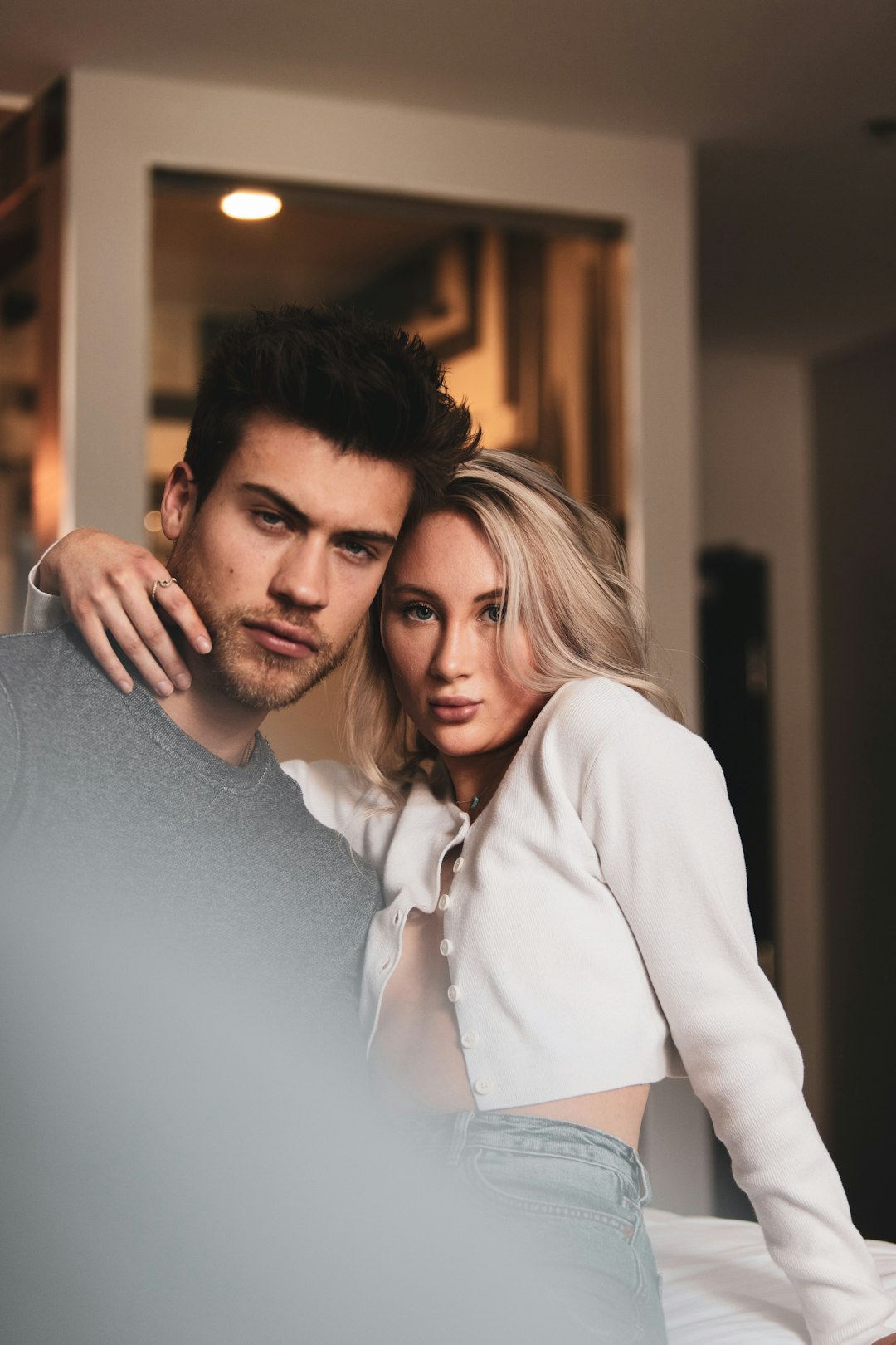 man in white dress shirt hugging woman in gray long sleeve shirt