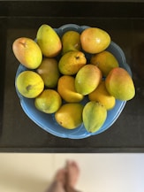 yellow citrus fruits on blue ceramic bowl