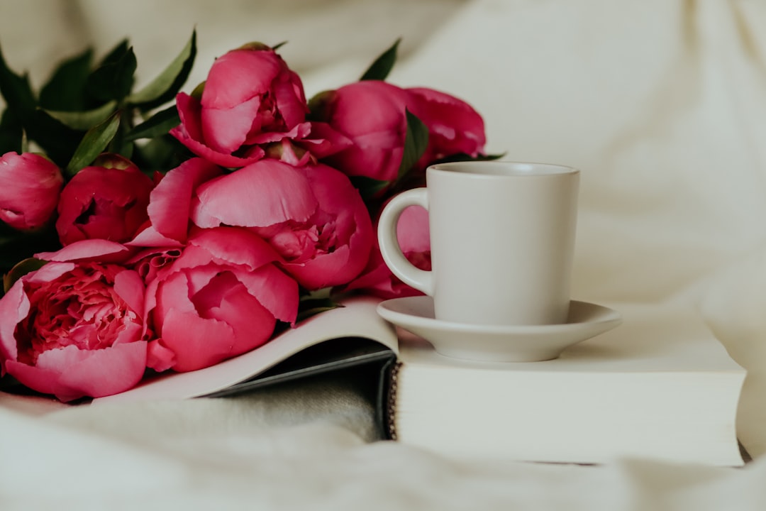 pink roses on white ceramic mug on white ceramic saucer