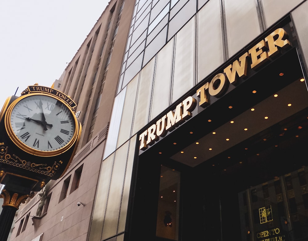 um relógio ao lado de um edifício que diz torre de Trump
