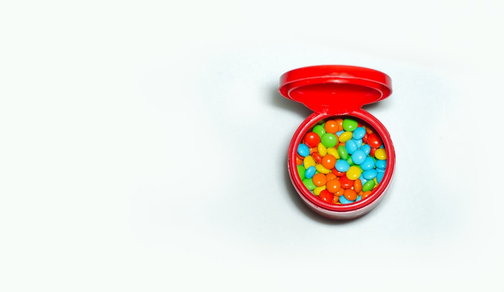 red round plastic container with candies