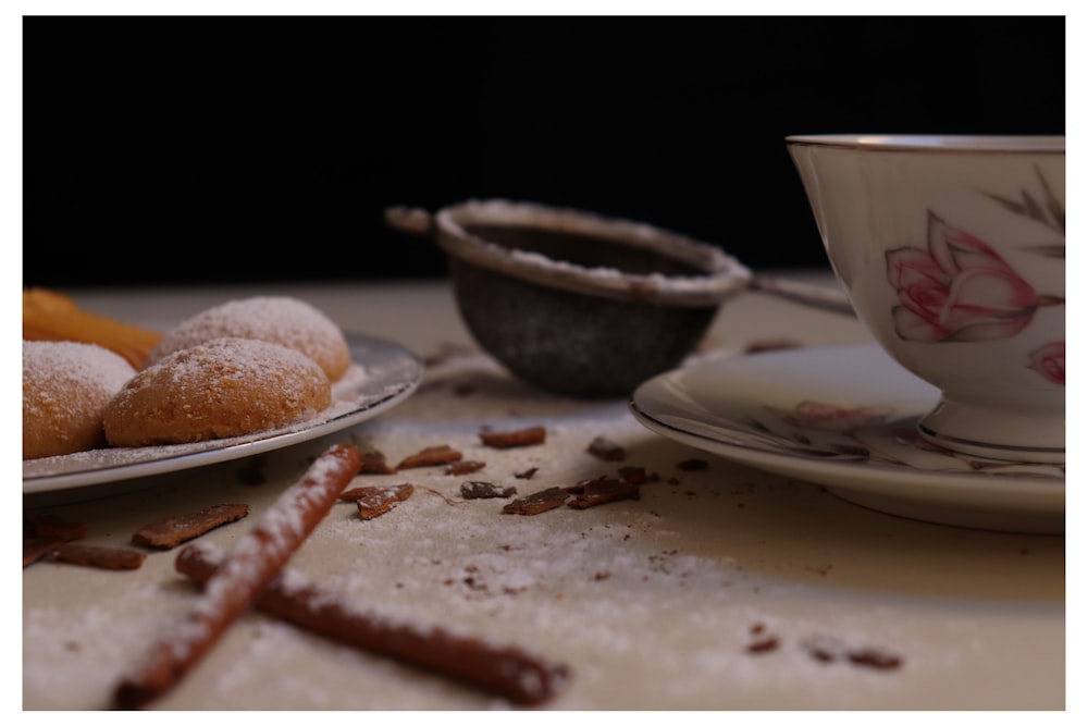 white ceramic cup on white ceramic saucer beside brown bread