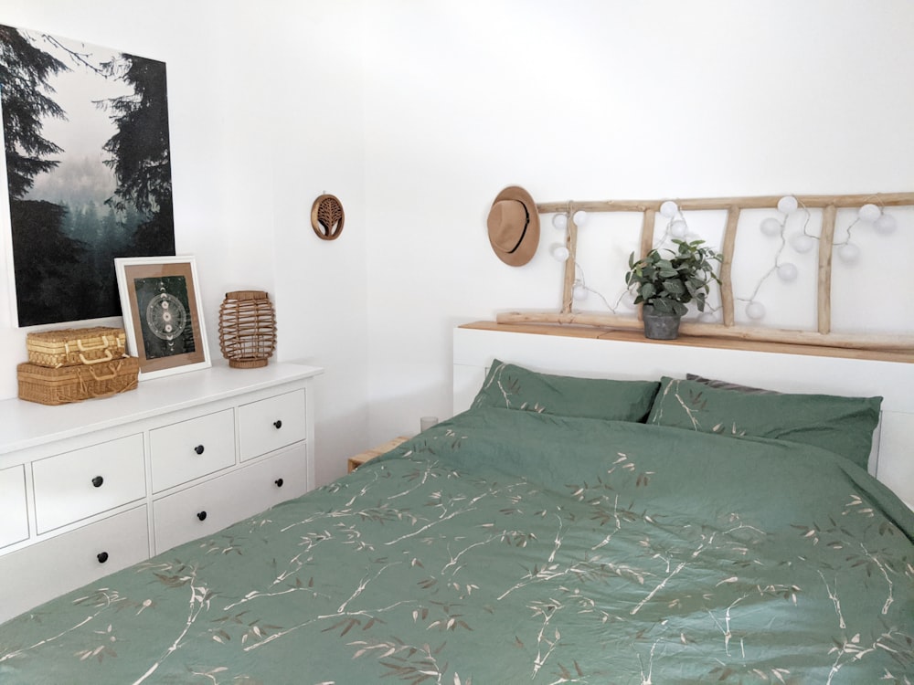 brown wooden cabinet beside green bed