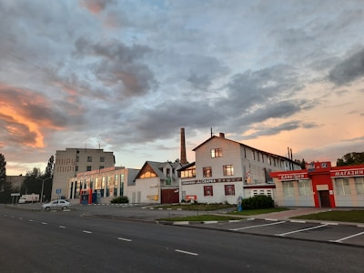 Close-up of a gas meter with industrial buildings in the background during sunset.