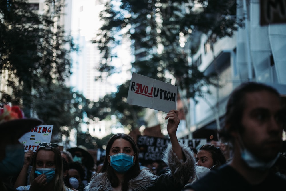 woman holding white and black signage