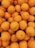 A pile of fresh oranges with a smooth texture and vibrant color, closely packed together. The surface of each orange displays slight variations with small dimples and natural imperfections.