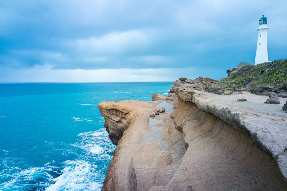 brown rock formation near blue sea under blue sky during daytime