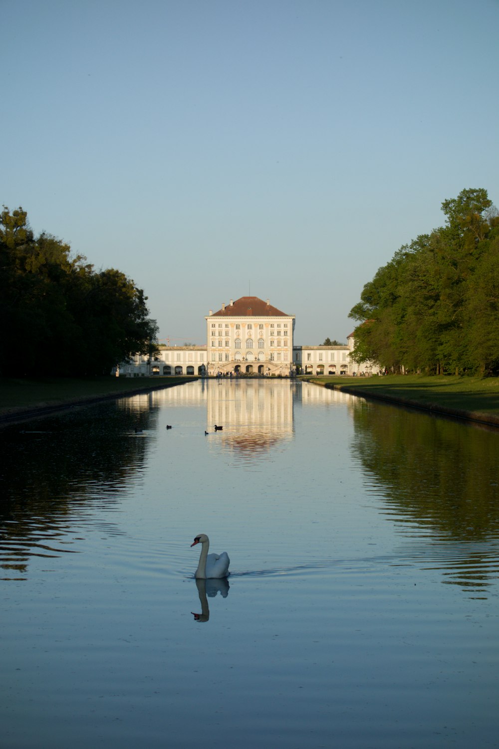 brown and white concrete building near green trees and river during daytime