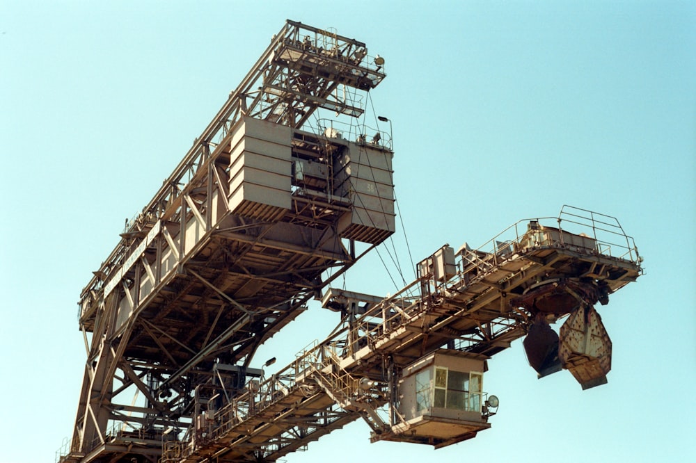 man in black jacket standing on brown metal tower