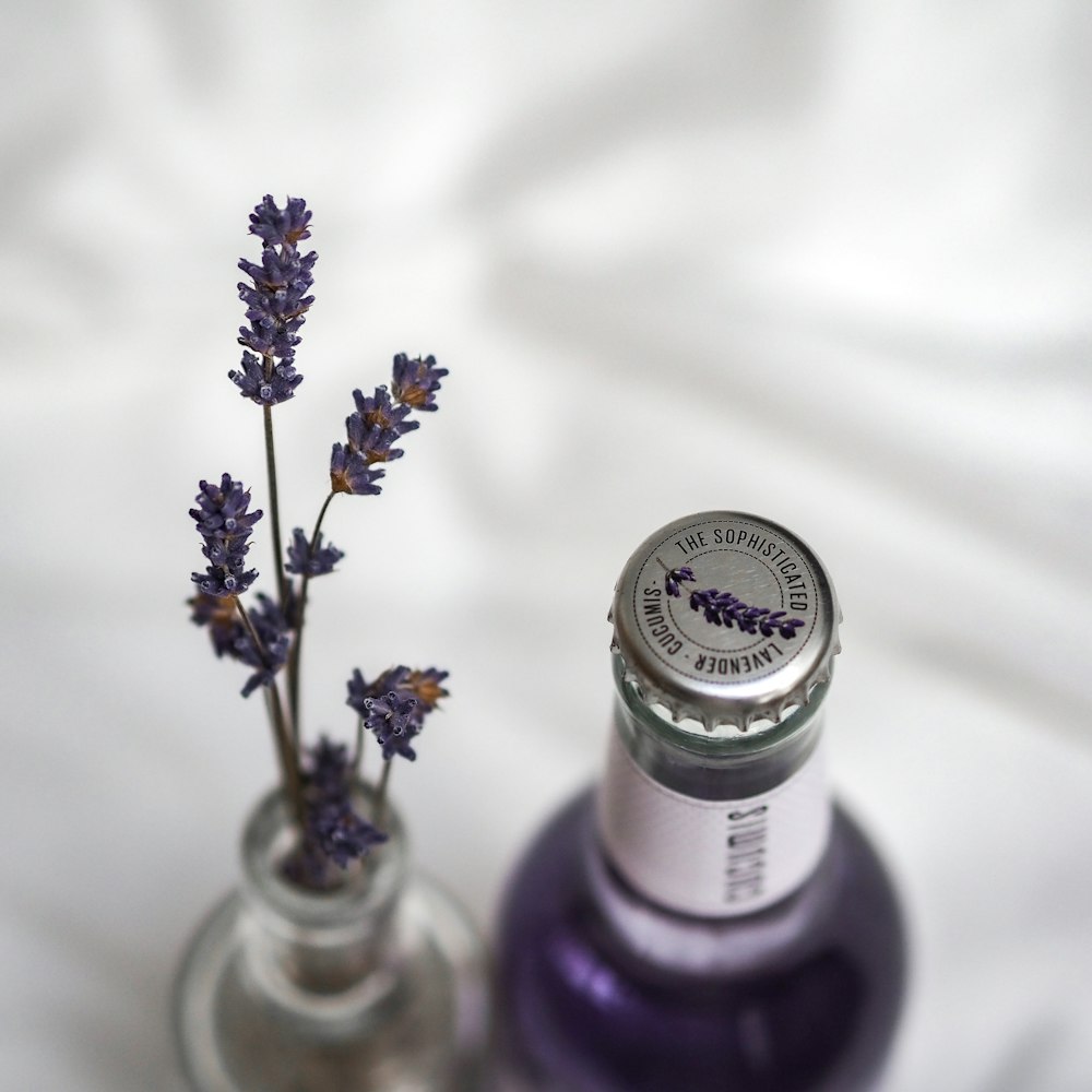 투명 유리 병에 보라색과 흰색 꽃