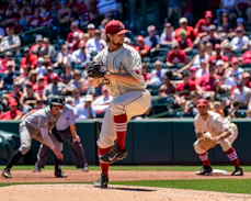 man in white and black baseball jersey shirt and red baseball cap