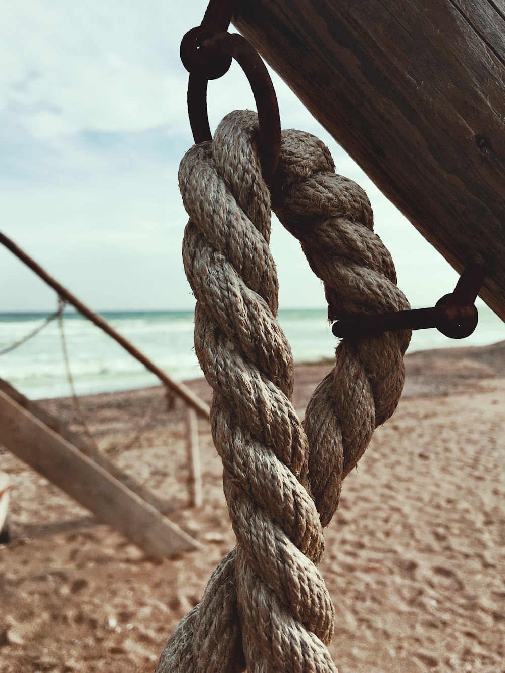 una corda appesa al lato di una barca su una spiaggia