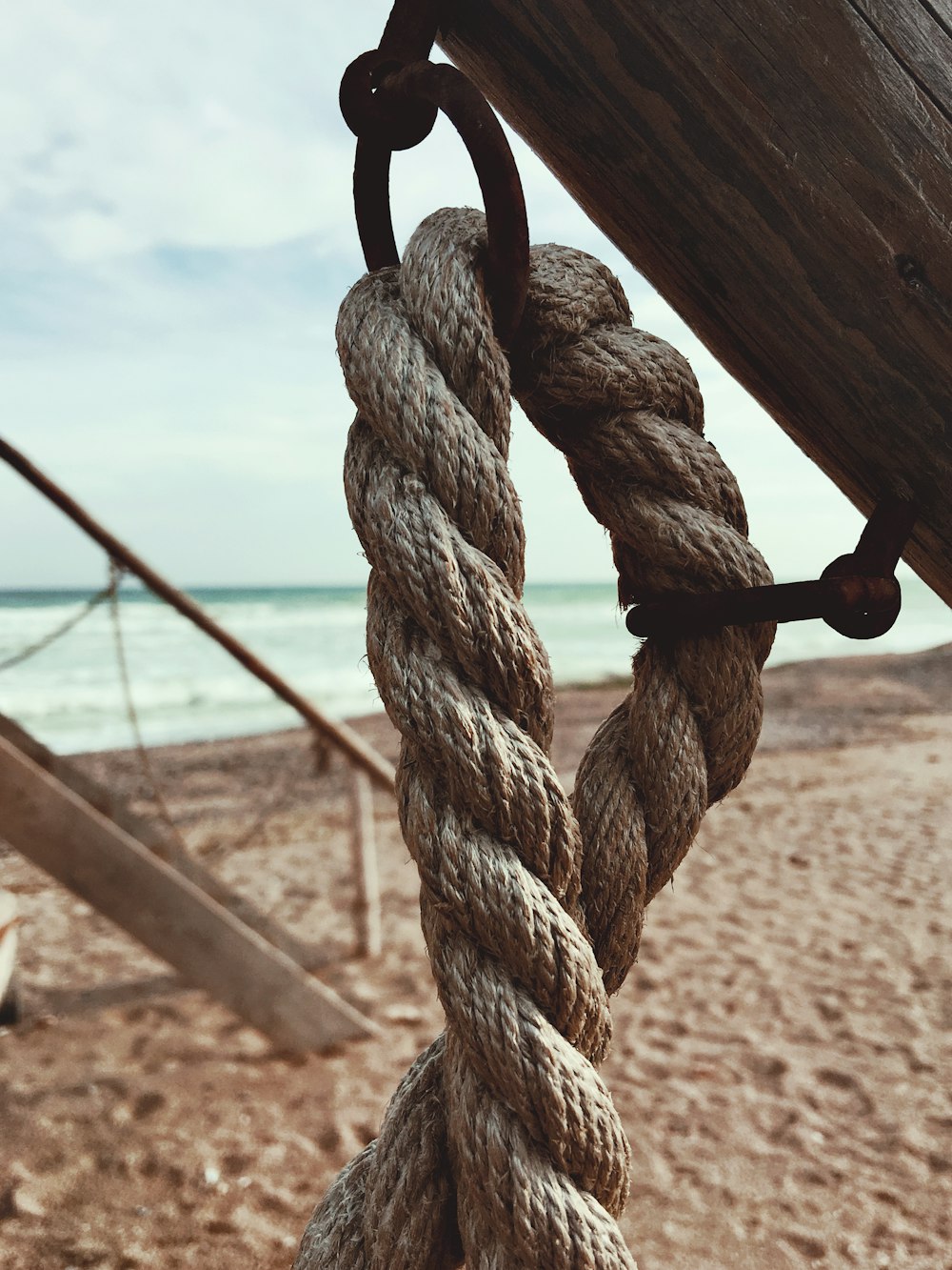a rope hanging from the side of a boat on a beach