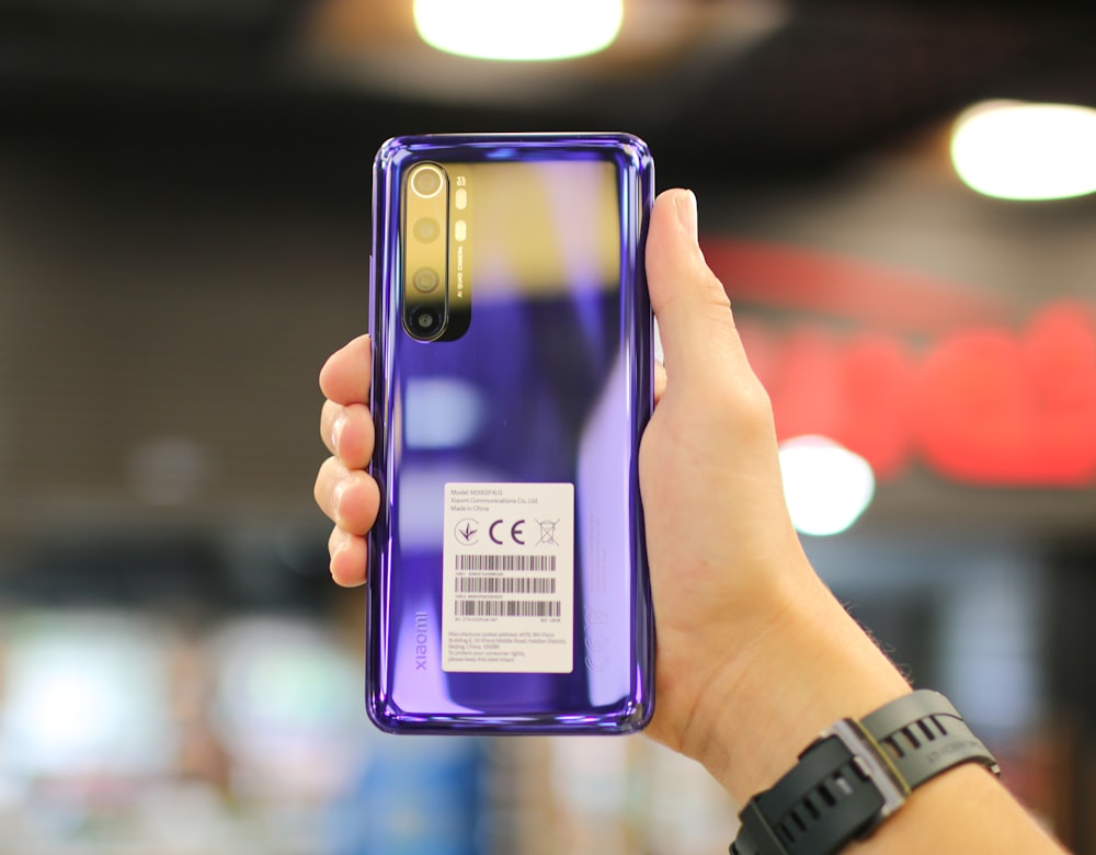 person holding silver iphone 6 with purple case