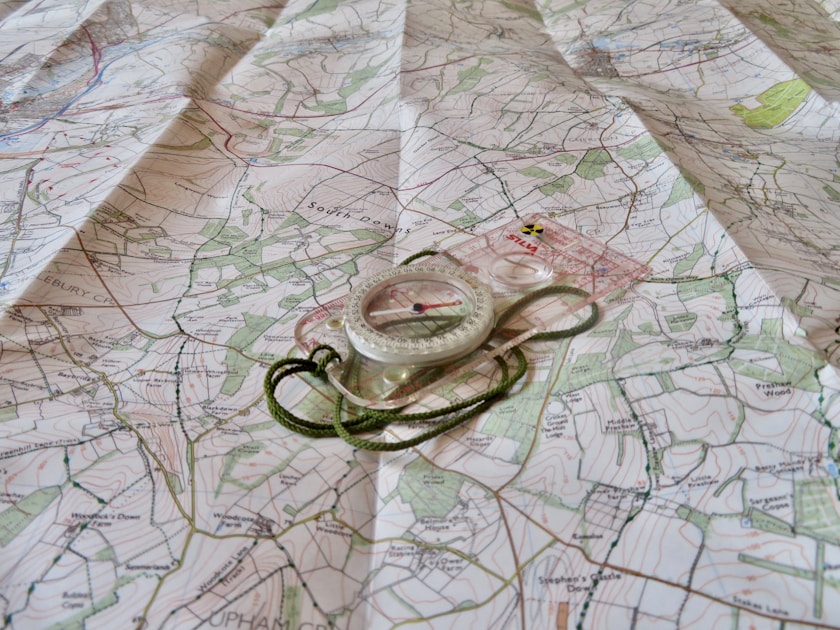 Hunter checking GPS watch with topo map display in mountain terrain