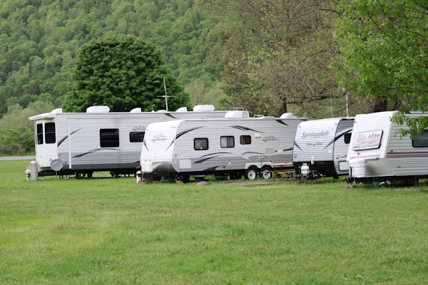 White and brown touring caravan parked on a grass pitch during daytime