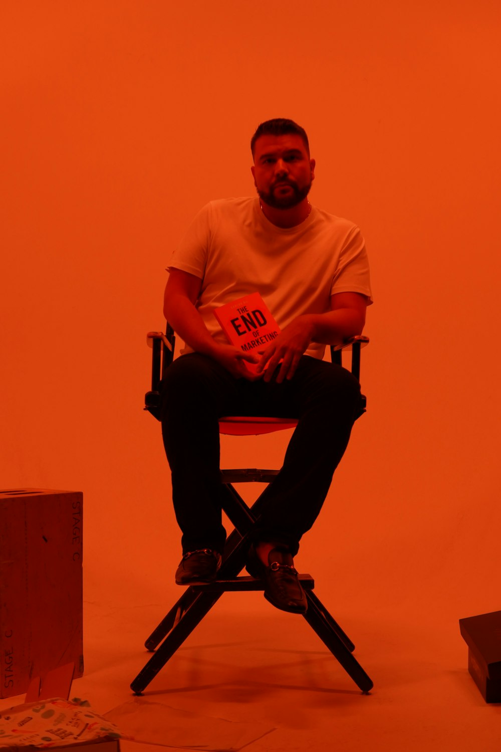 man in white crew neck t-shirt sitting on black folding chair