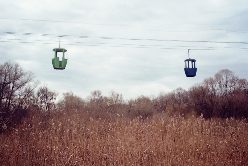 green and black cable car over brown grass field during daytime