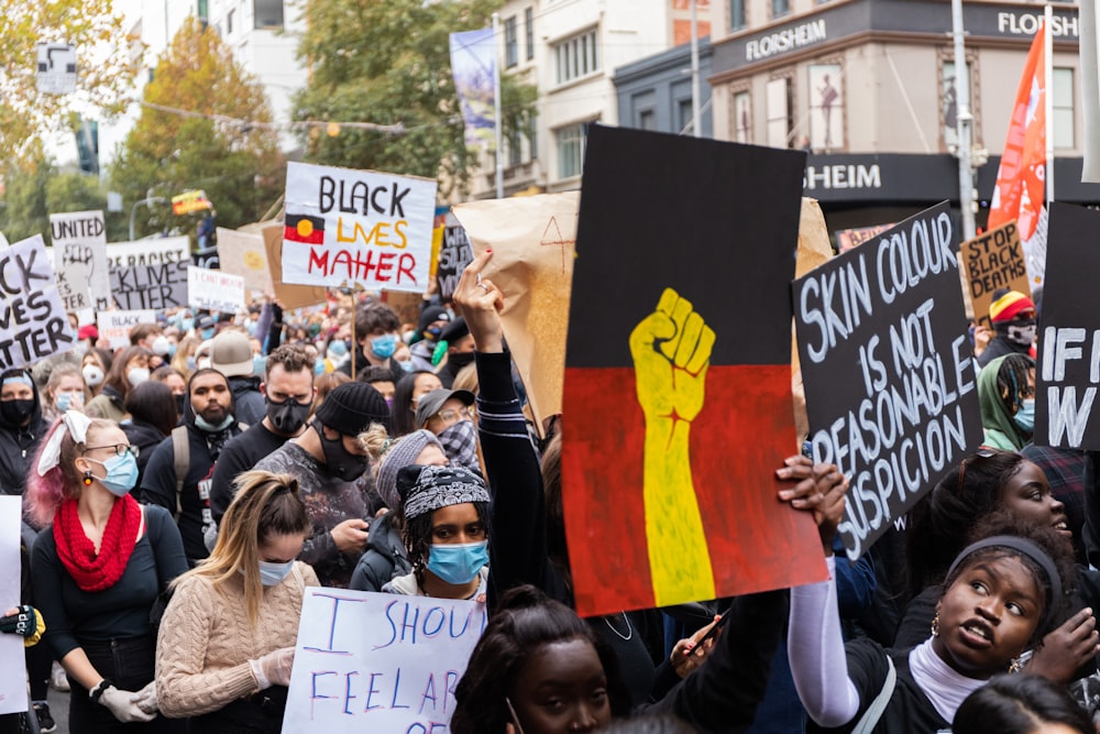 people holding a signage during daytime