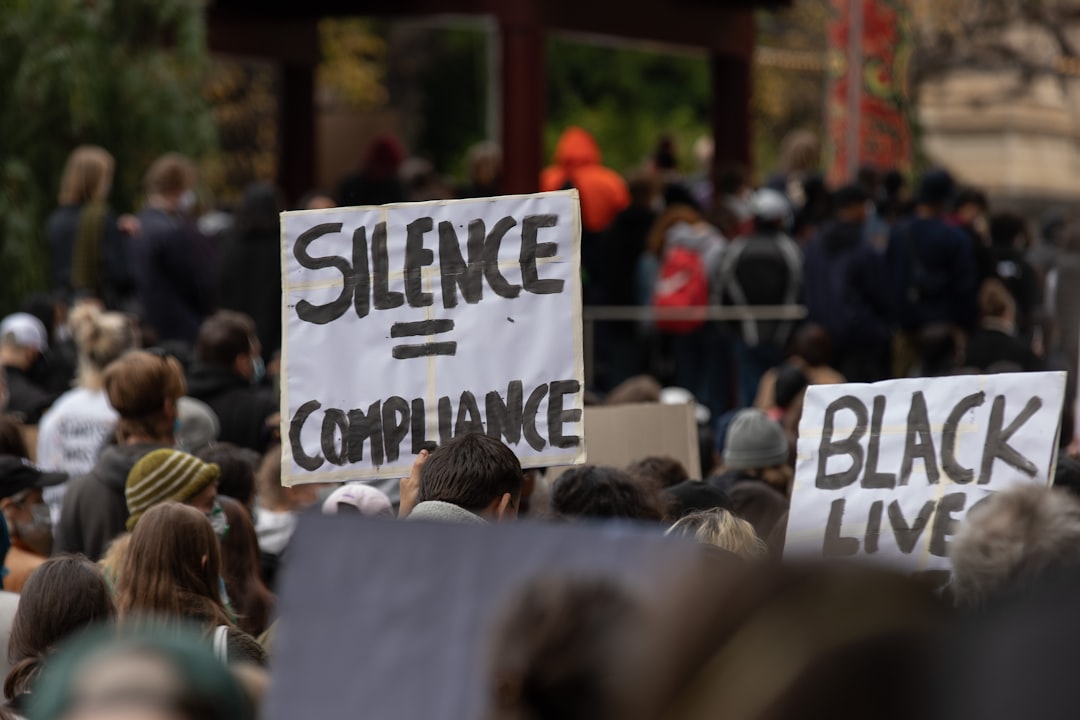 people holding white and black signage during daytime