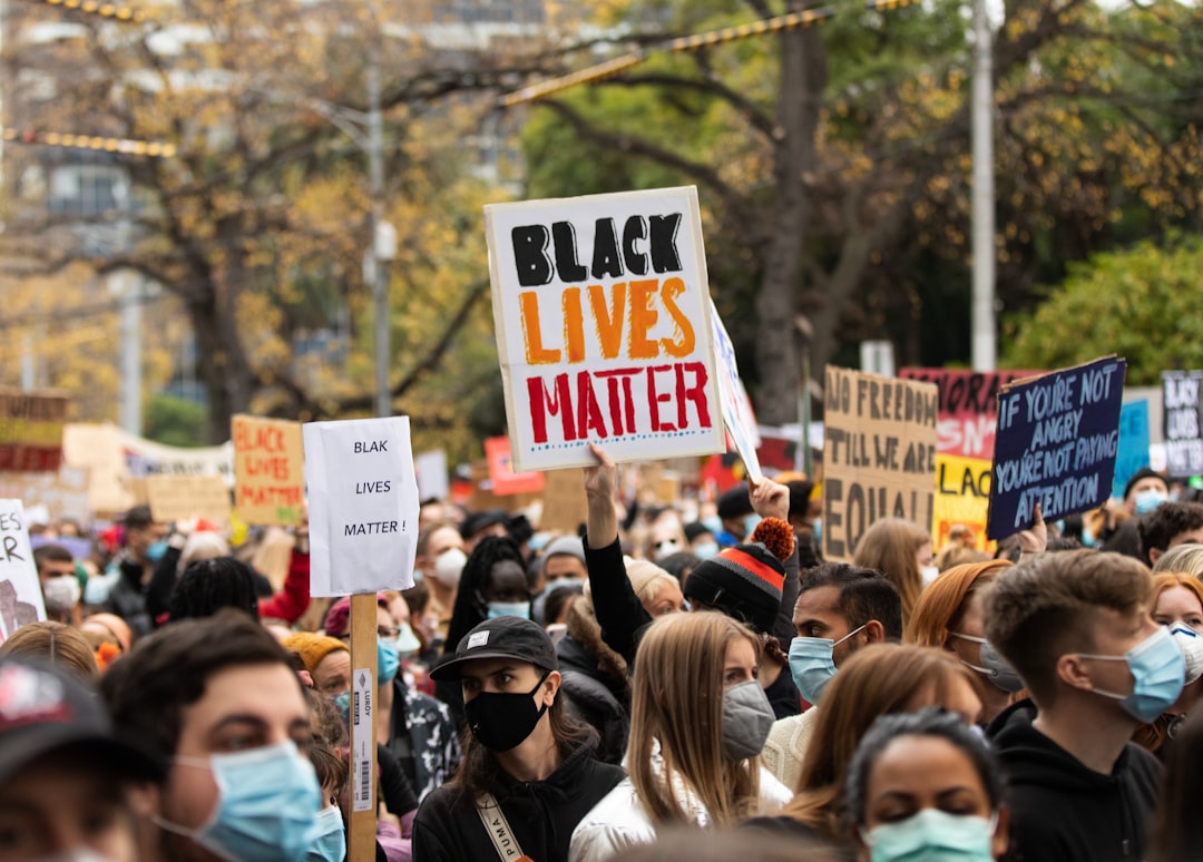 people holding white and red signage during daytime