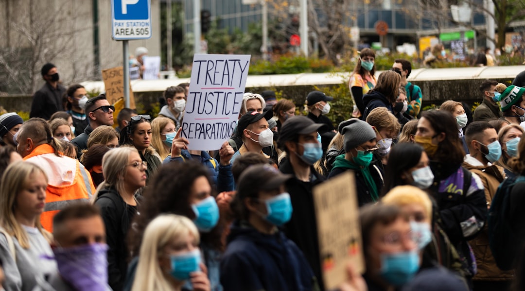 people holding blue and white signage during daytime