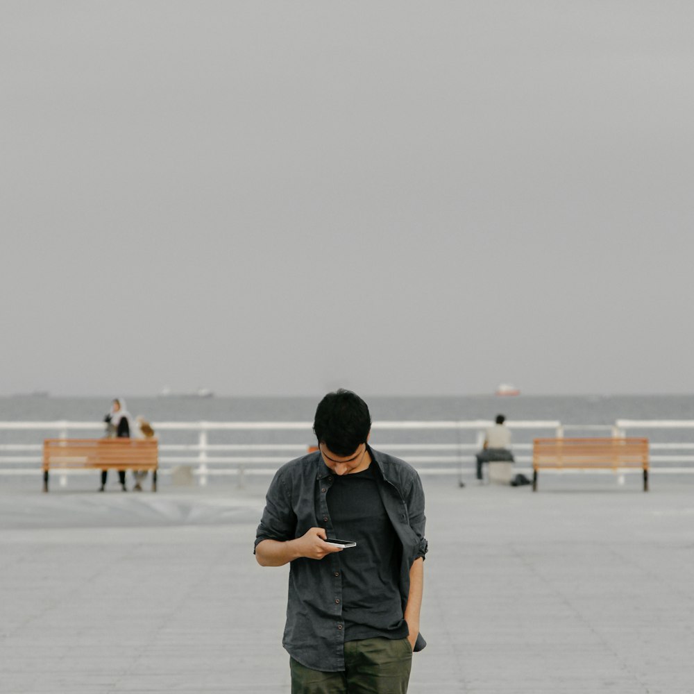 man in black hoodie standing on white floor during daytime