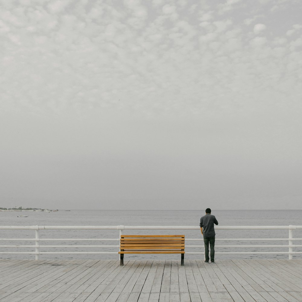 person in black jacket and pants standing on dock during daytime