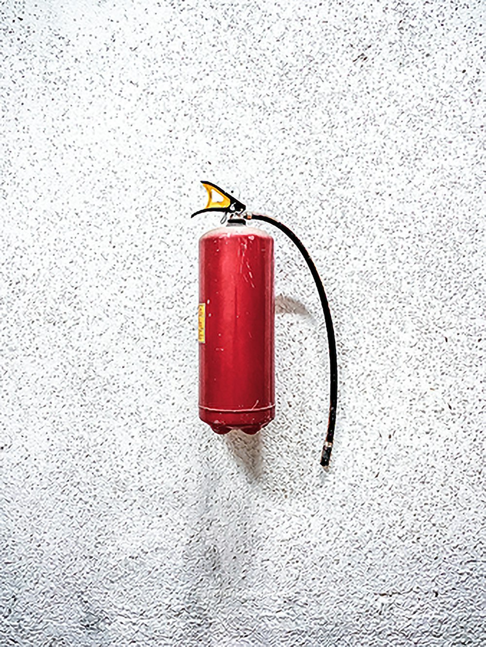 red fire extinguisher on white wall