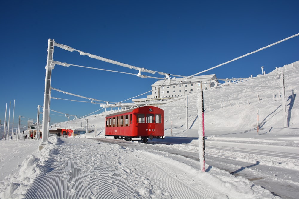 red cable car over snow covered ground during daytime