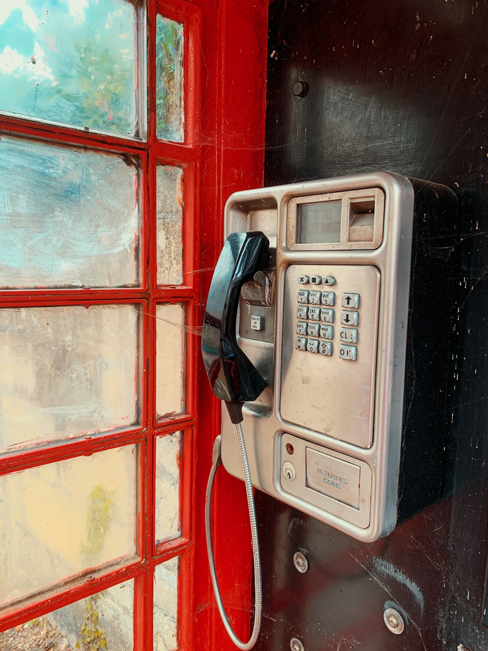 black and silver telephone on red and blue wooden wall