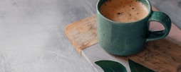 green ceramic mug with brown liquid