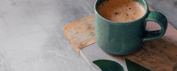 green ceramic mug with brown liquid