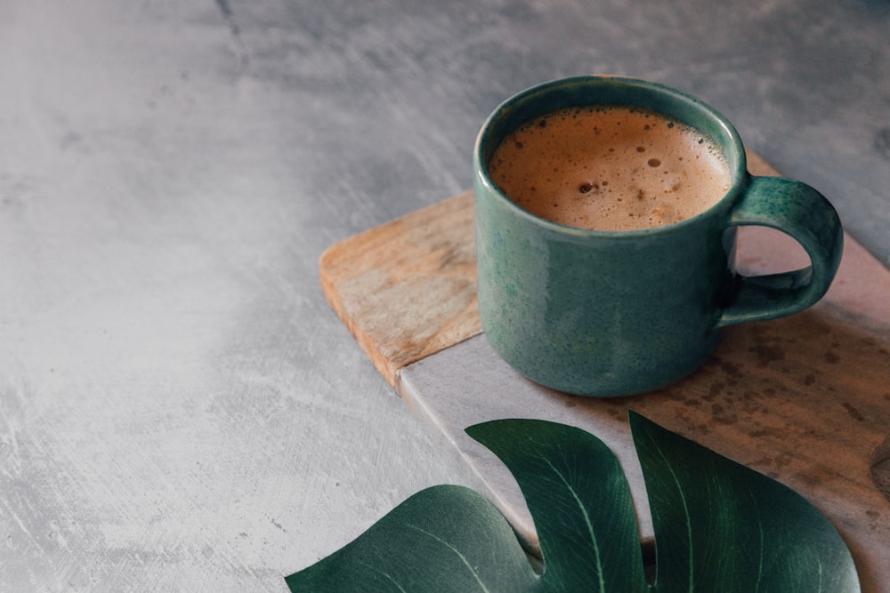 green ceramic mug with brown liquid