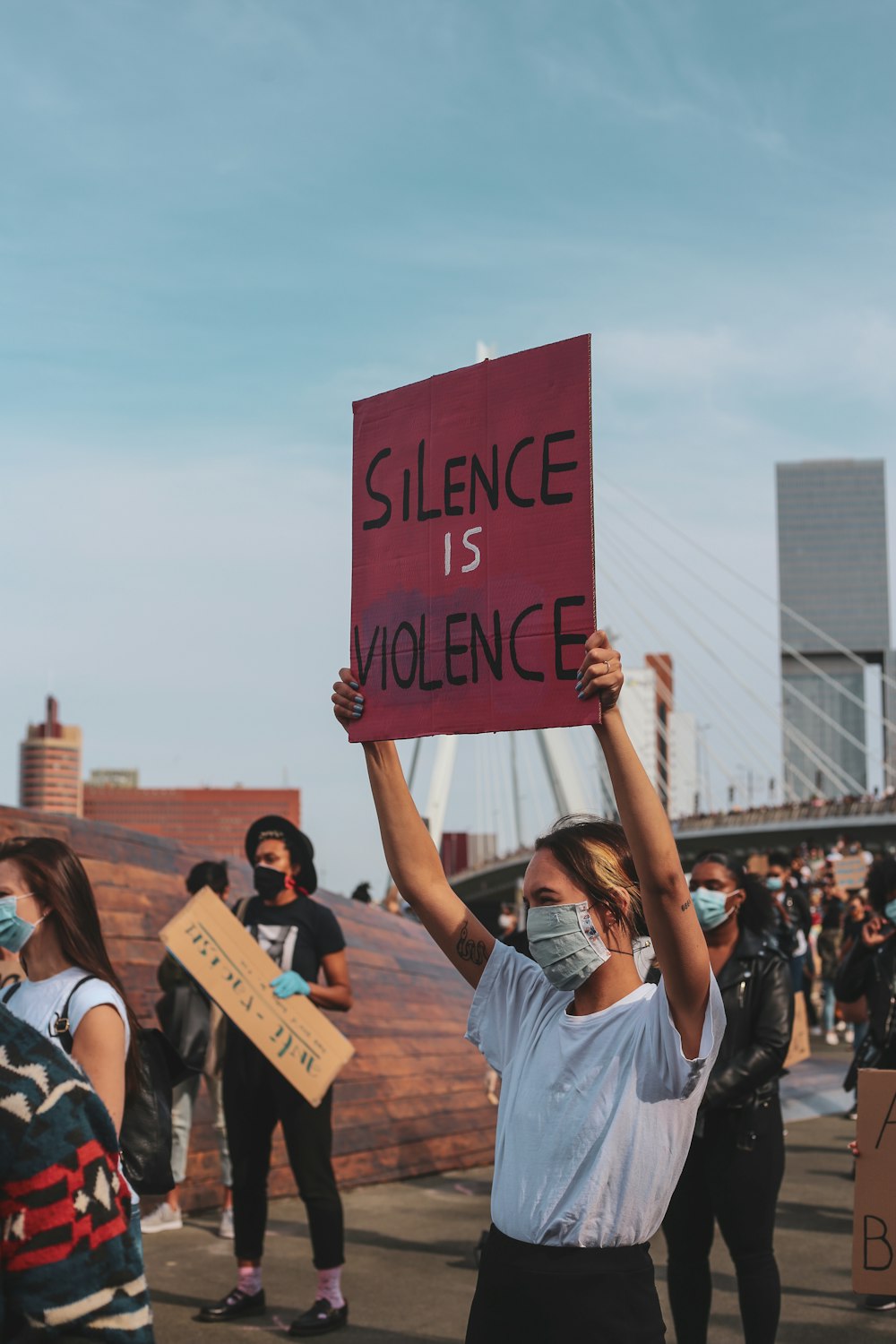 people holding love me printed signage during daytime