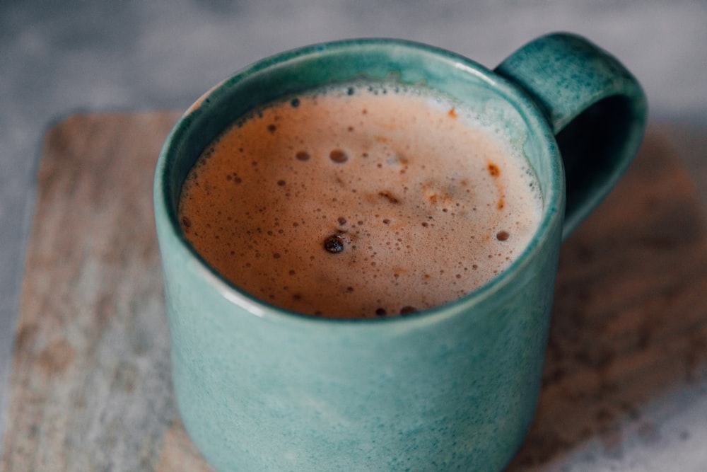 white ceramic mug with brown liquid