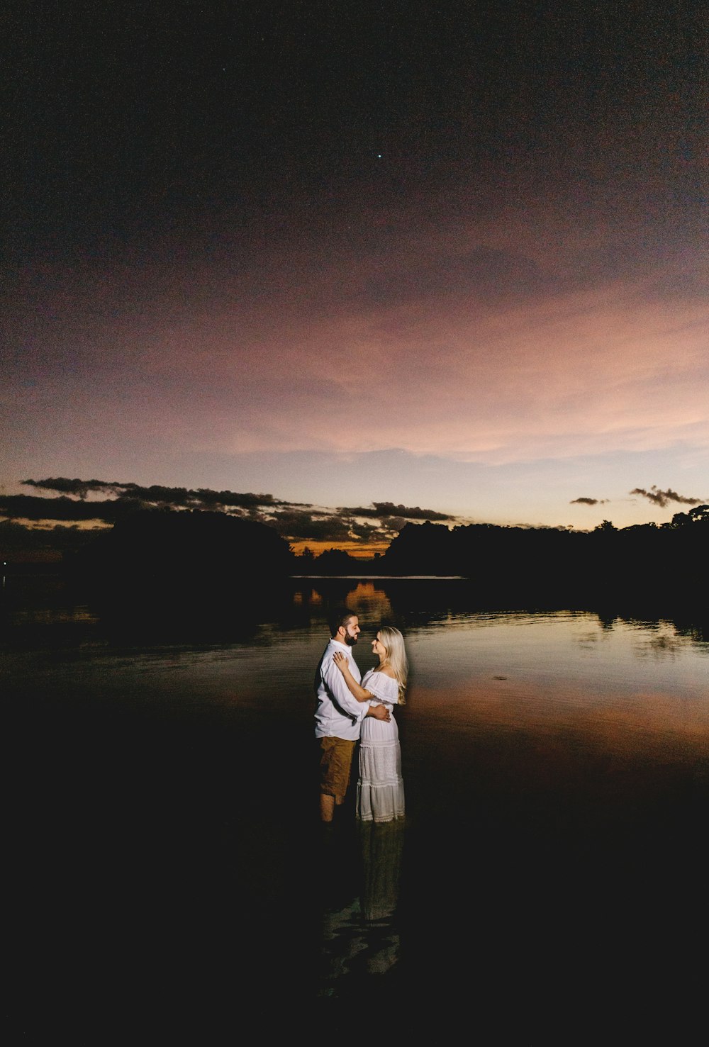 woman in white long sleeve shirt standing beside woman in white long sleeve shirt during sunset