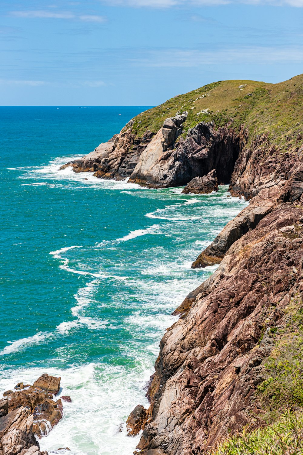 brown rock formation beside body of water during daytime