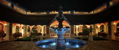 Outdoor lawn with decorative lighting and a fountain, perfect for evening gatherings.