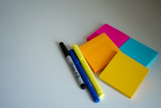 A collection of colorful sticky notes and a pen on a desk.