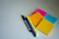 Close-up of vibrant pens and sticky notes arranged neatly on a bright workspace.