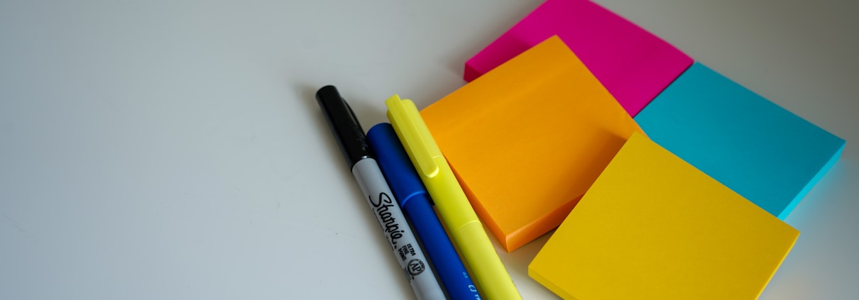 SWOT blue and black pen beside orange sticky notes