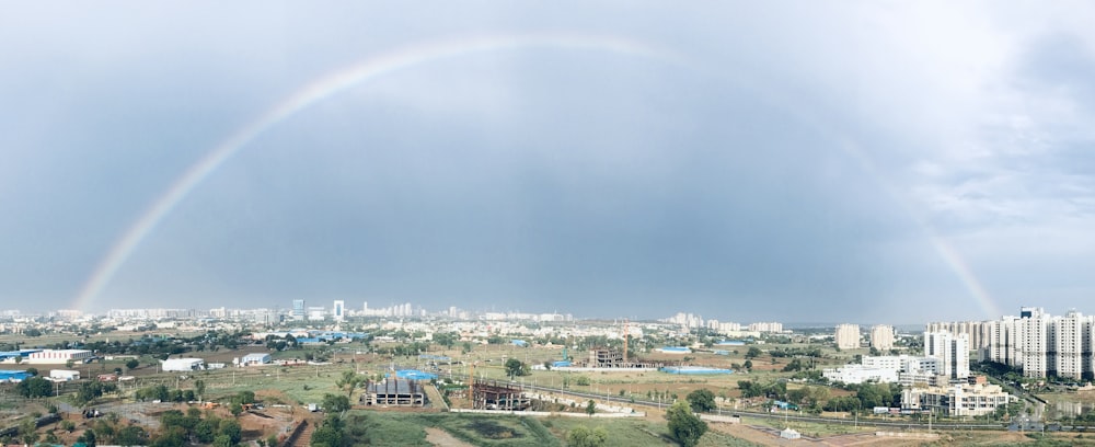 city with high rise buildings under rainbow