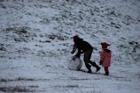 A family building a snowman in a winter wonderland.