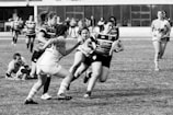 Rugby players deflecting a tackle, aiming for the score.